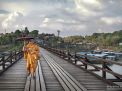 Monk on wooden bridge